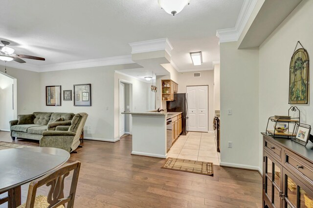 kitchen with crown molding, open shelves, a ceiling fan, wood finished floors, and a peninsula