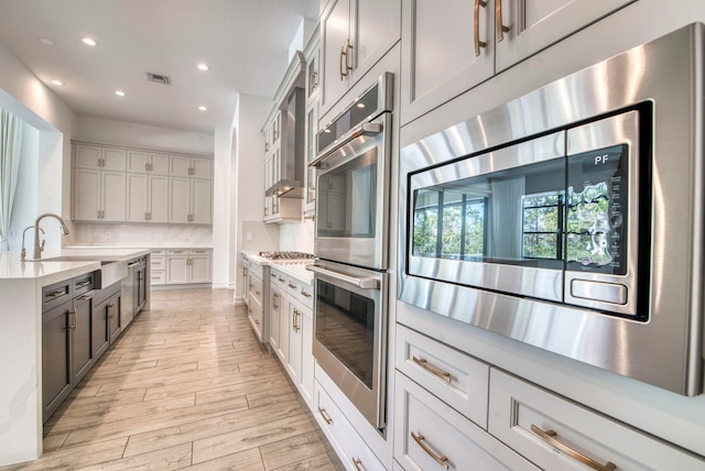 kitchen with tasteful backsplash, light wood-type flooring, sink, and stainless steel appliances