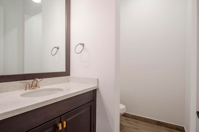 bathroom featuring hardwood / wood-style flooring, vanity, and toilet