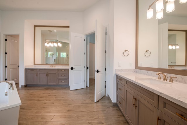 bathroom with hardwood / wood-style floors, vanity, and lofted ceiling