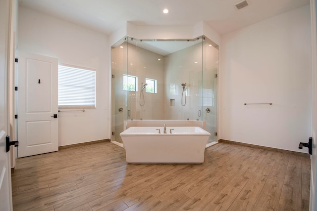 bathroom with independent shower and bath and hardwood / wood-style flooring