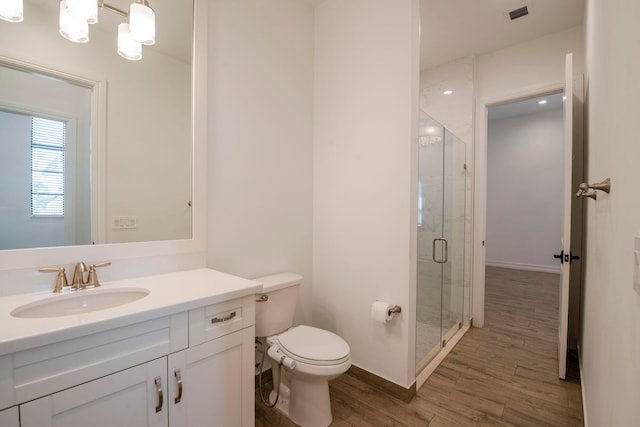 bathroom featuring walk in shower, vanity, wood-type flooring, and toilet