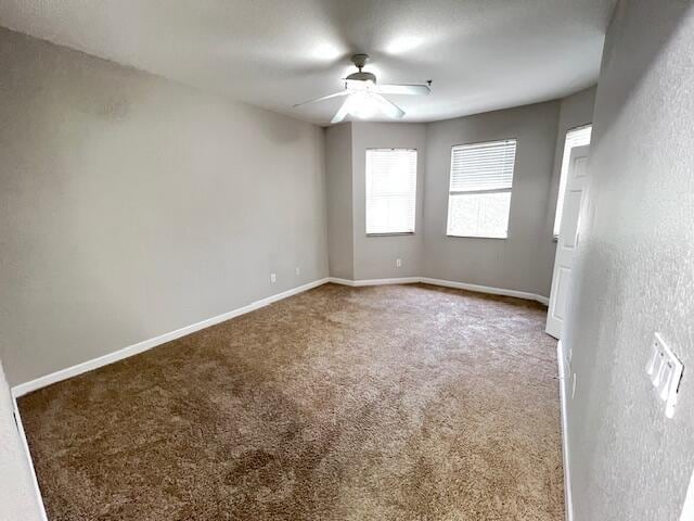 carpeted spare room featuring ceiling fan