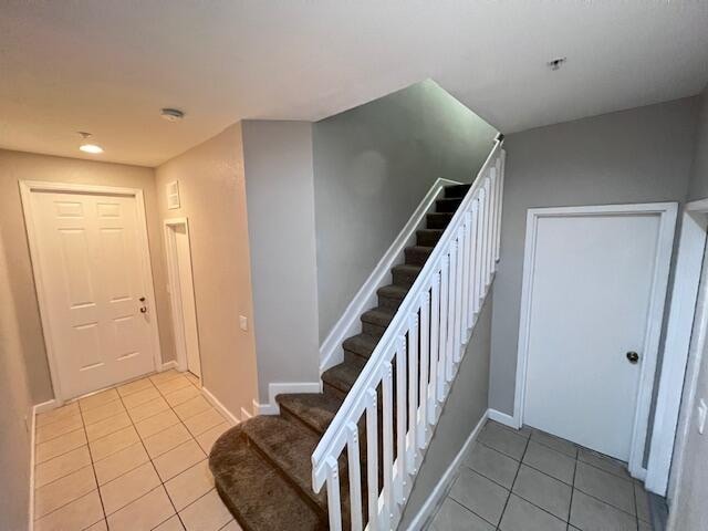 staircase featuring tile patterned flooring