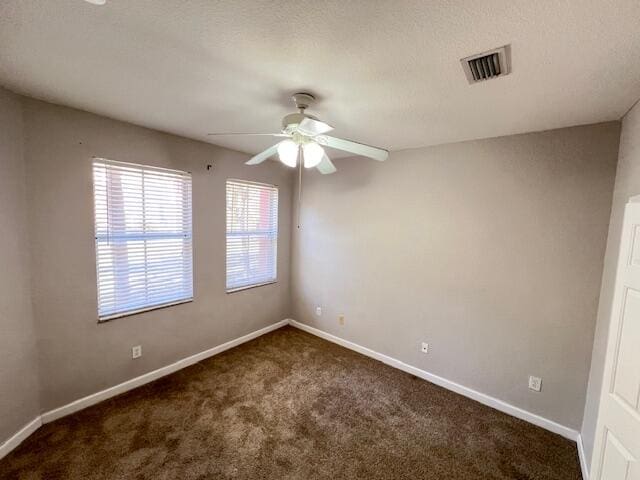 carpeted spare room with ceiling fan and a textured ceiling