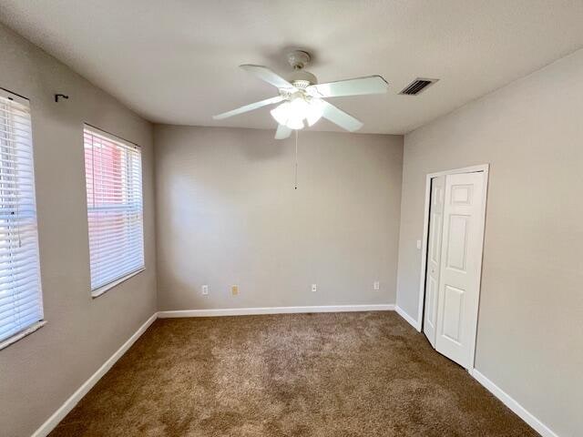 carpeted empty room featuring ceiling fan