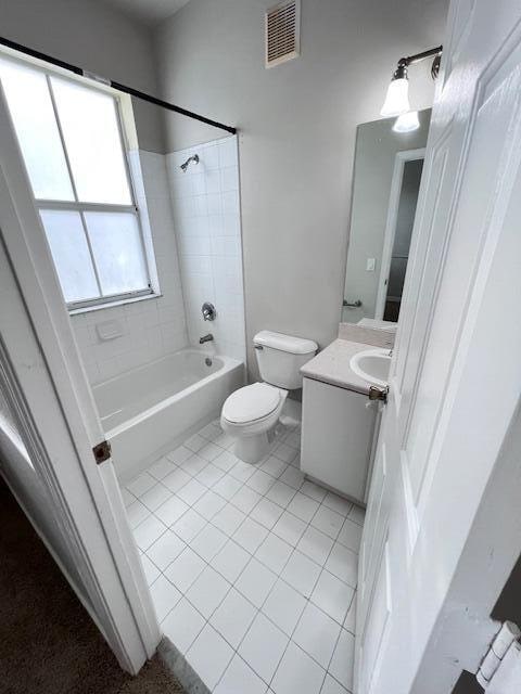 full bathroom with vanity, toilet, tile patterned flooring, and tiled shower / bath