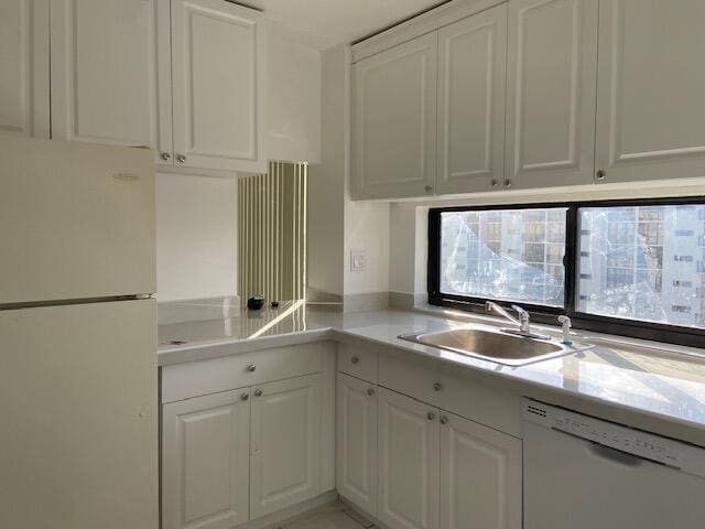 kitchen with white cabinets, sink, and white appliances