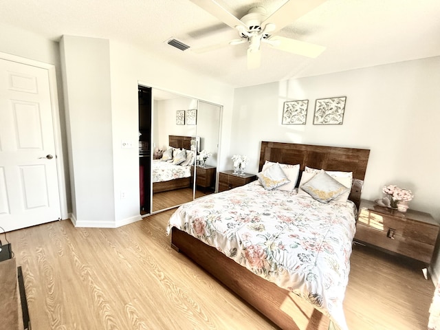 bedroom featuring light wood-type flooring, ceiling fan, and a closet