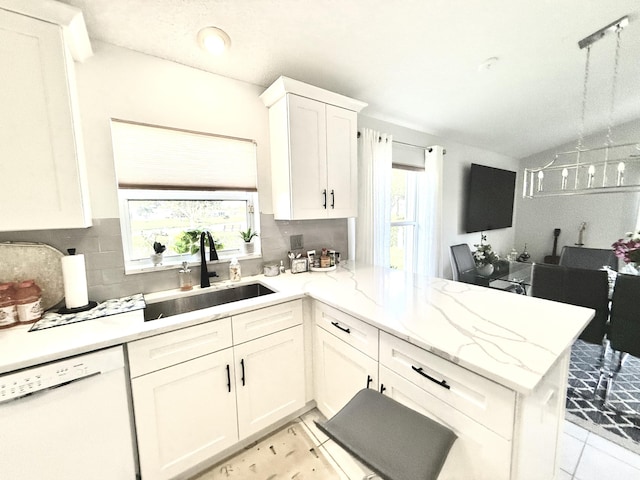 kitchen with sink, white cabinetry, light stone counters, dishwasher, and kitchen peninsula