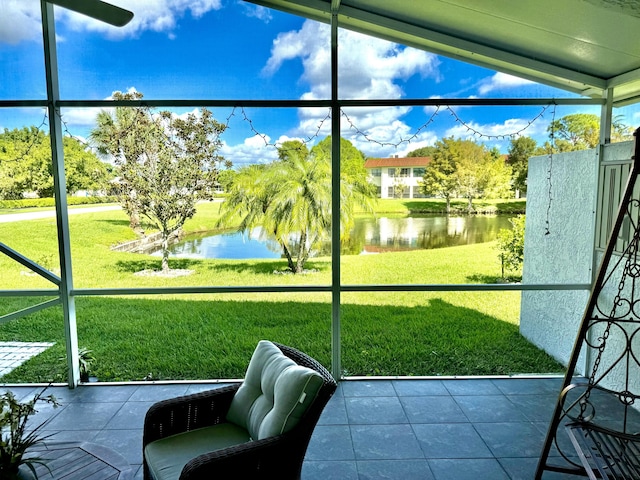 sunroom featuring a water view