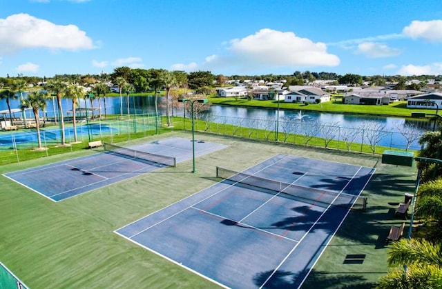 view of tennis court featuring a water view