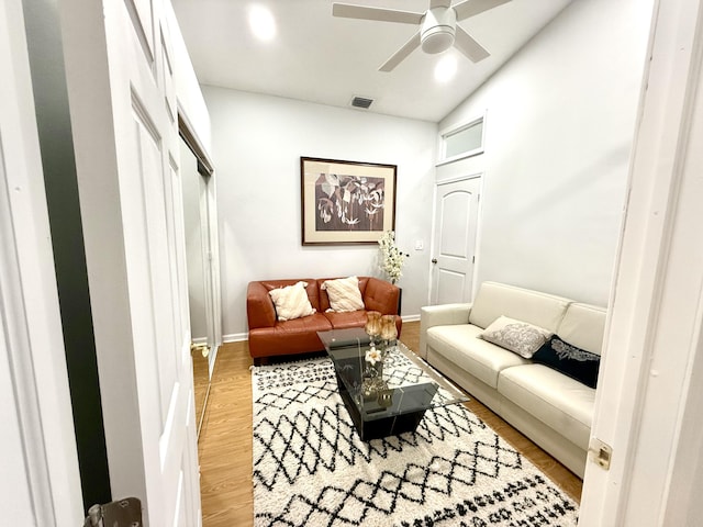 living room with ceiling fan, vaulted ceiling, and hardwood / wood-style floors