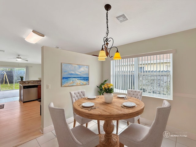 dining room with light tile patterned flooring, visible vents, baseboards, and a notable chandelier