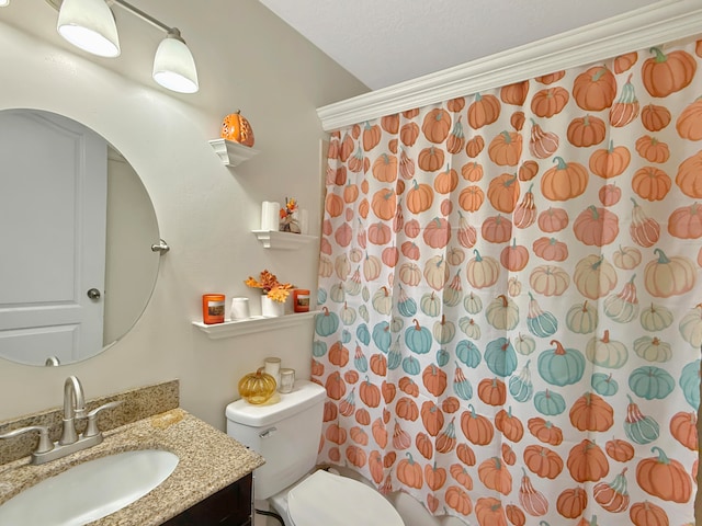 bathroom featuring toilet, vanity, and walk in shower