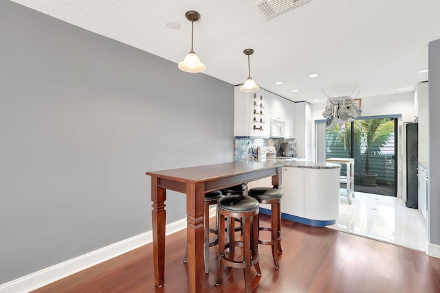 dining area featuring a textured ceiling and dark hardwood / wood-style flooring