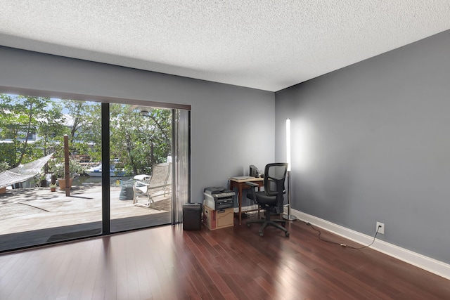 home office with a textured ceiling and dark hardwood / wood-style flooring