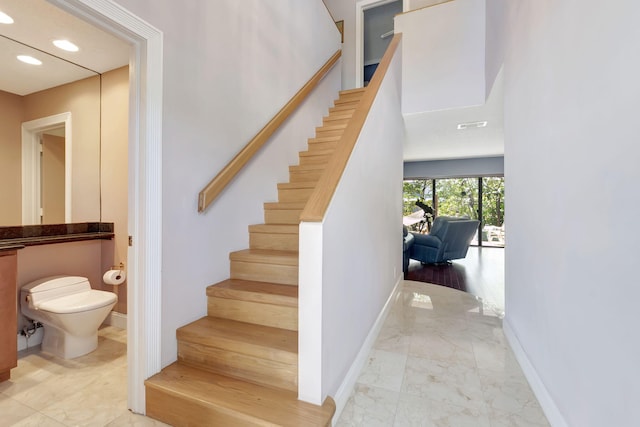 staircase with baseboards, recessed lighting, and marble finish floor