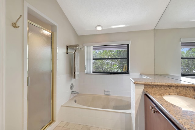 bathroom with tile patterned flooring, vanity, a textured ceiling, a shower stall, and a bath