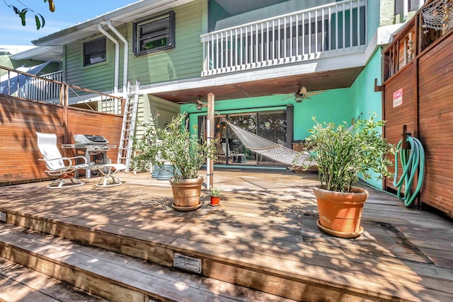 wooden deck with area for grilling and ceiling fan