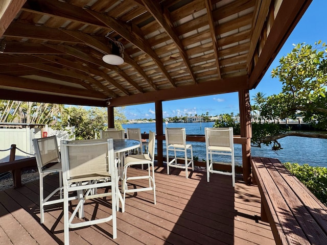 view of dock with outdoor dining area and a water view
