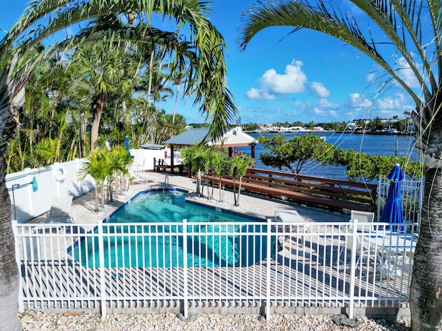 view of pool with a patio, fence, a water view, and a fenced in pool