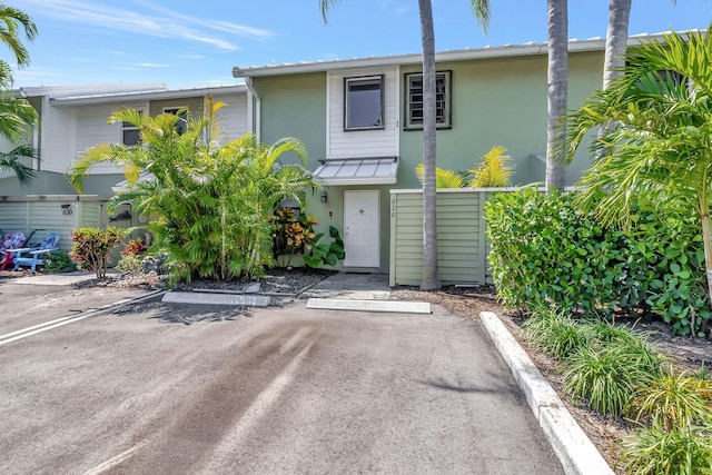 view of property featuring stucco siding and uncovered parking