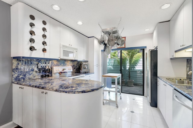 kitchen featuring a sink, recessed lighting, decorative backsplash, and white appliances