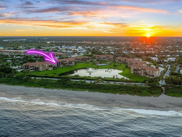 aerial view at dusk featuring a water view