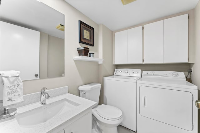 bathroom with toilet, washer and dryer, and vanity