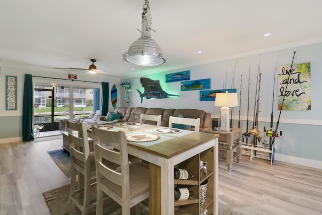 dining space with ceiling fan, hardwood / wood-style floors, and ornamental molding