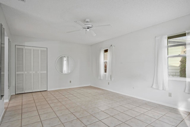 tiled spare room featuring ceiling fan and a textured ceiling