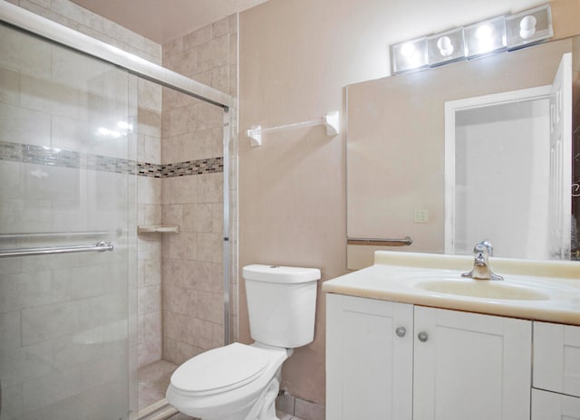 bathroom with toilet, walk in shower, and vanity