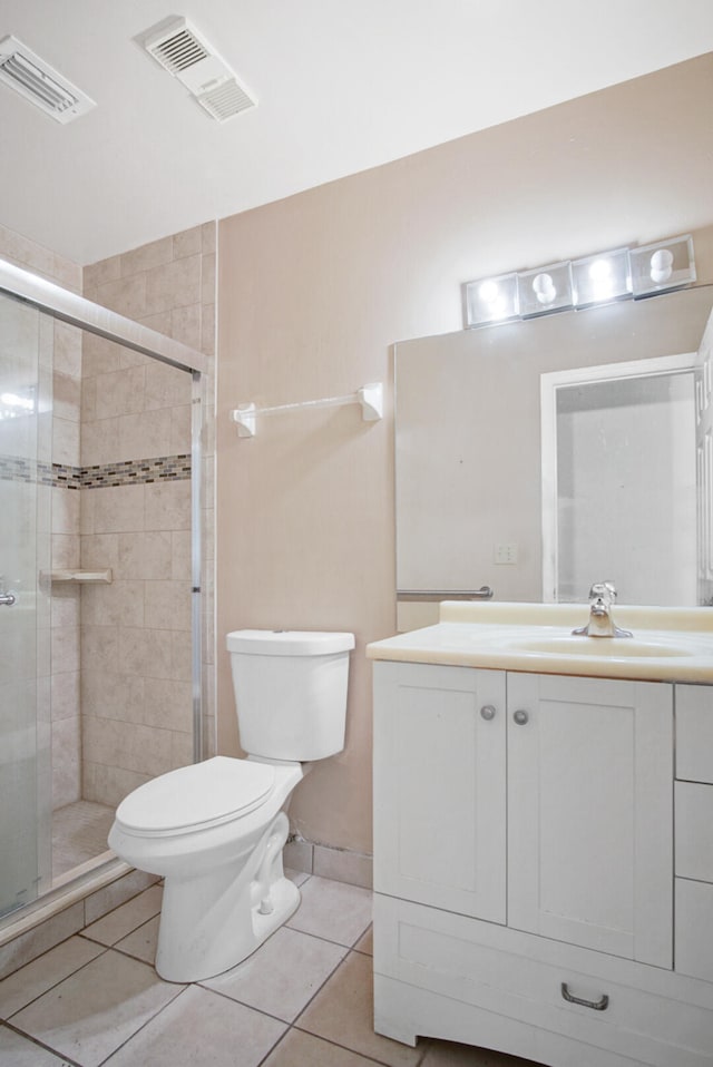 bathroom featuring a shower with door, vanity, toilet, and tile patterned flooring