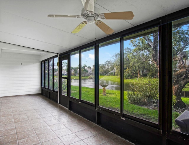 unfurnished sunroom with a water view, ceiling fan, and a wealth of natural light