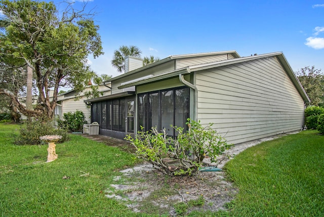 view of side of home with a lawn and a sunroom