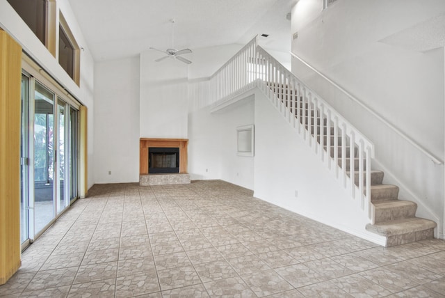 unfurnished living room with ceiling fan and high vaulted ceiling