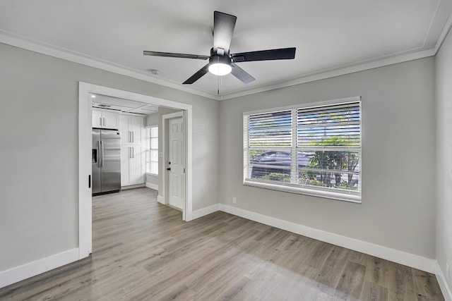 empty room featuring ceiling fan, ornamental molding, and light wood-type flooring