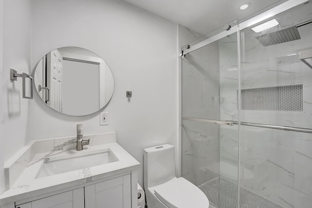 bathroom featuring vanity, toilet, and a shower with shower door