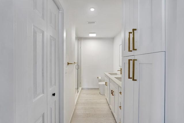 bathroom featuring toilet, a shower with shower door, vanity, and wood-type flooring