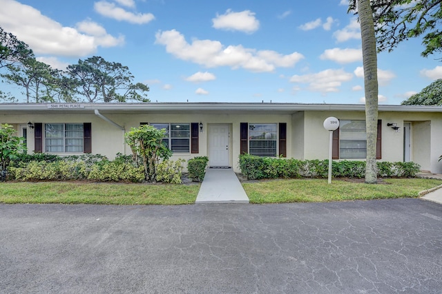 single story home featuring a front lawn