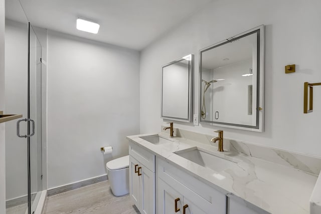 bathroom with toilet, an enclosed shower, hardwood / wood-style floors, and vanity