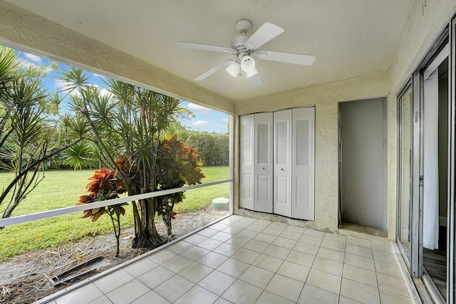 unfurnished sunroom featuring ceiling fan