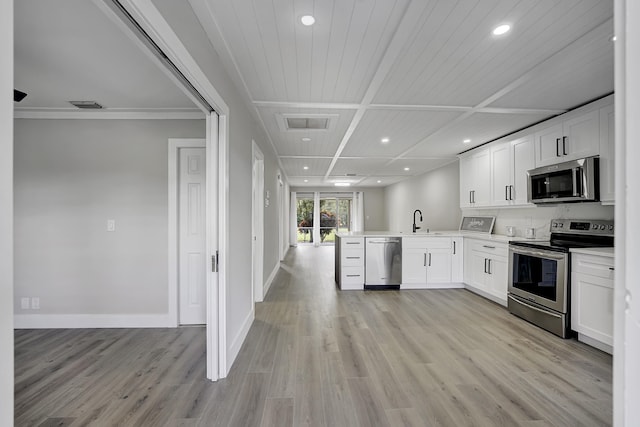 kitchen featuring light hardwood / wood-style flooring, white cabinets, kitchen peninsula, and stainless steel appliances