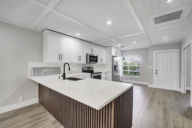 kitchen featuring light wood-type flooring, stainless steel appliances, sink, and kitchen peninsula