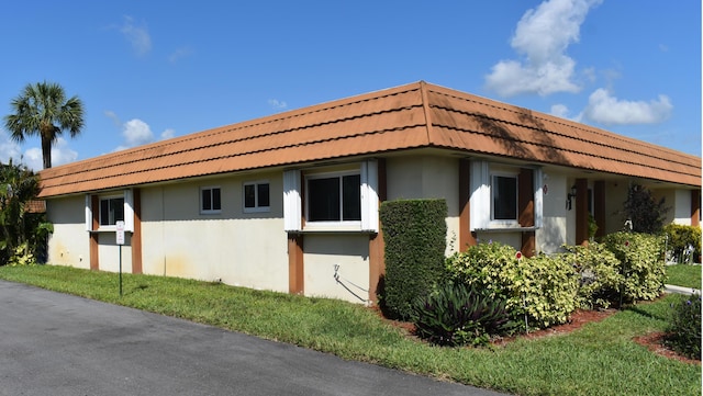 view of side of home with a yard