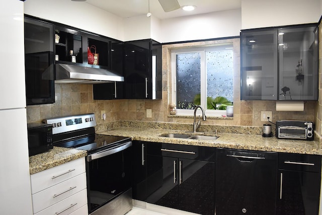 kitchen featuring light stone countertops, sink, decorative backsplash, and black appliances