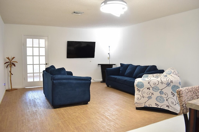 living room with hardwood / wood-style floors and a textured ceiling