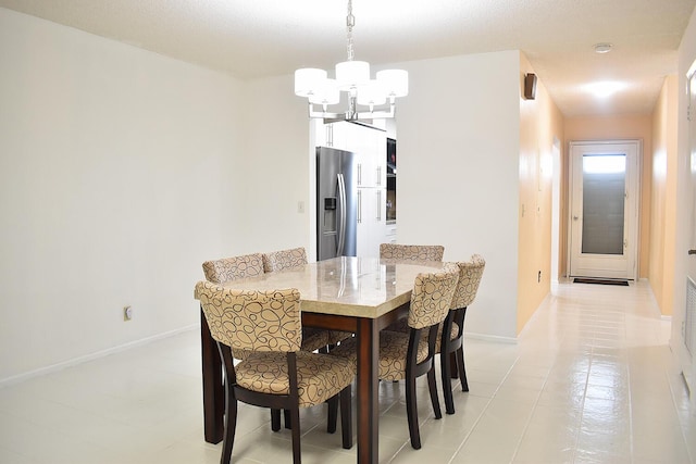 tiled dining space featuring an inviting chandelier