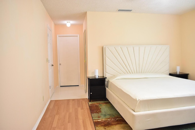 bedroom featuring wood-type flooring and a textured ceiling